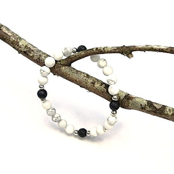 Handmade Serenity Bracelet – Howlite & Lava Stone Grounding & Calming hanging on branch